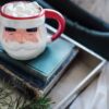 A pile of books with a Santa mug on top